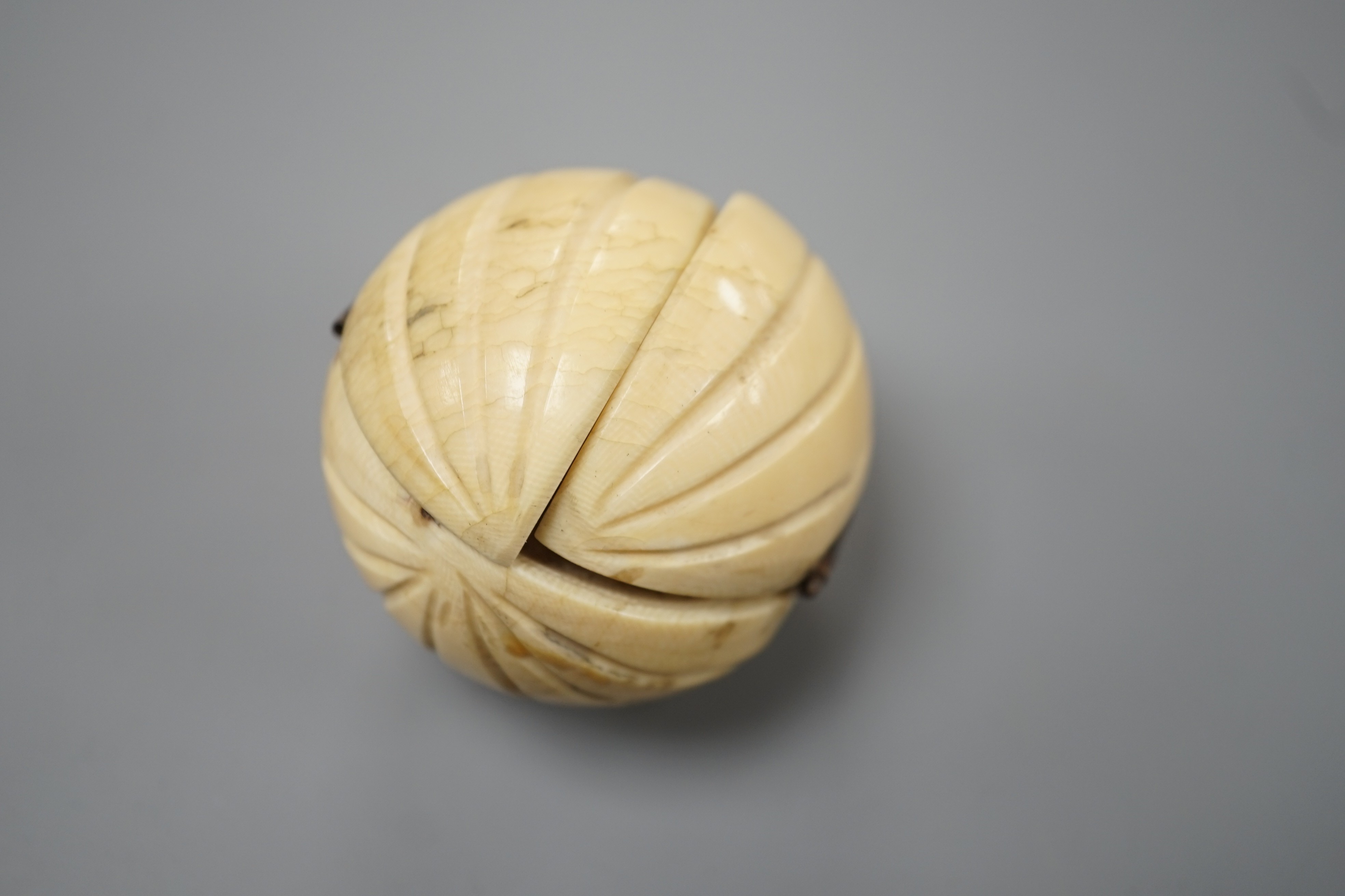 A 19th century Dieppe ivory globular triptych, possibly depicting Crimean war figures, 5.4cm diameter closed